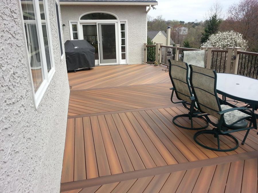 Large composite deck with patio furniture off the back of a home