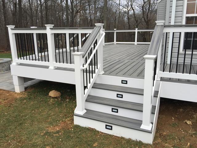 Composite deck with white railing, black balusters and stairs