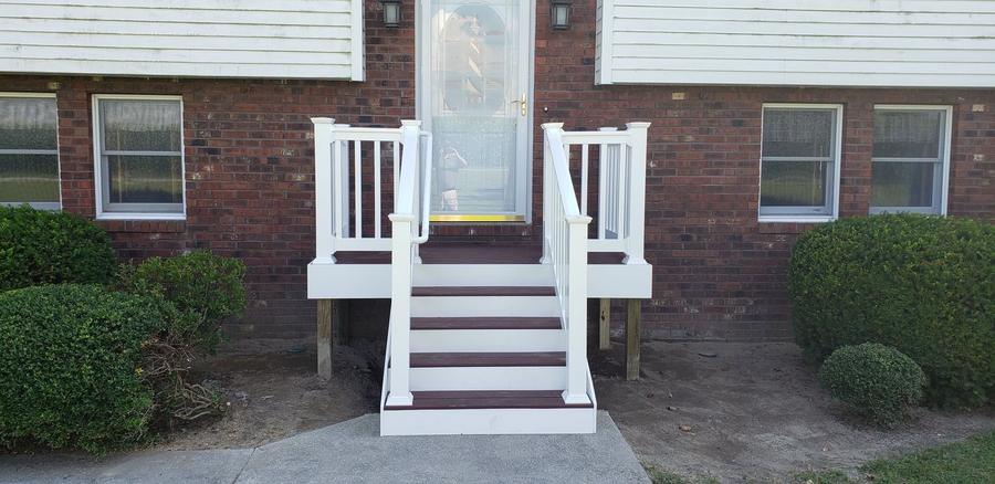 Brick home with newly built white front steps and railings