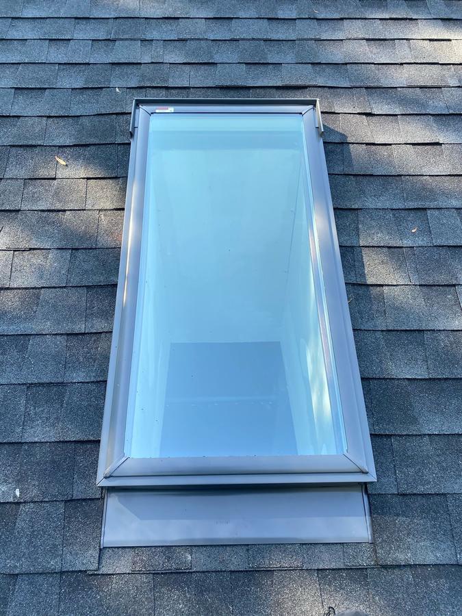 Newly installed skylight in an architectural shingle roof