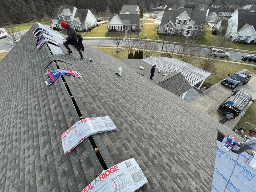Crew installing underlayment during a roof replacement